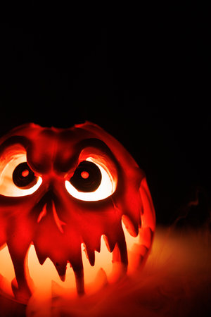 Spooky Halloween pumpkin with smoke and glowing carved face.の写真素材
