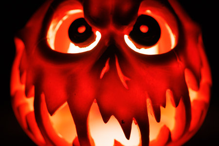 Evil Halloween lantern pumpkin glowing in spooky dark background.の写真素材