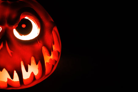 Spooky Halloween pumpkin lantern with scary glowing face.の写真素材