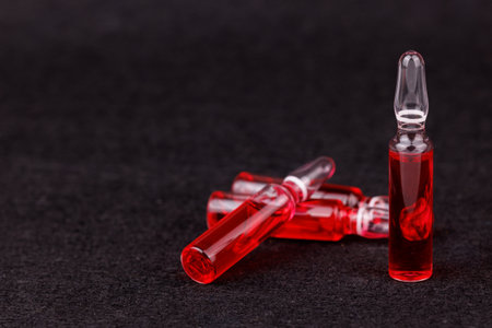 Red ampoules on black backdrop showing therapy and wellness