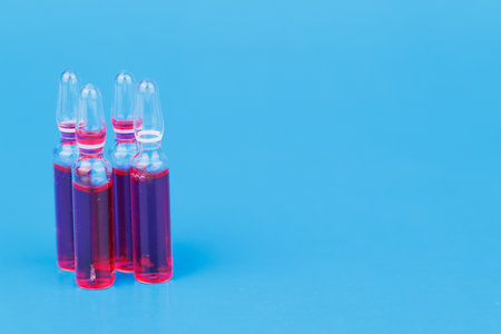 Ampoules displayed on blue background highlighting medical supplement and therapy