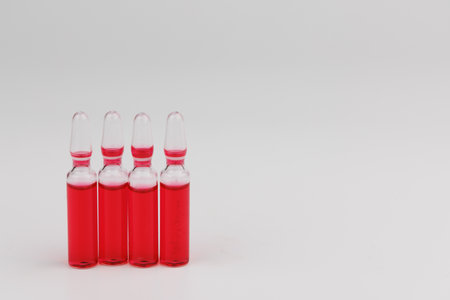 Red vitamin B12 ampoules for injection with glass vials on white background