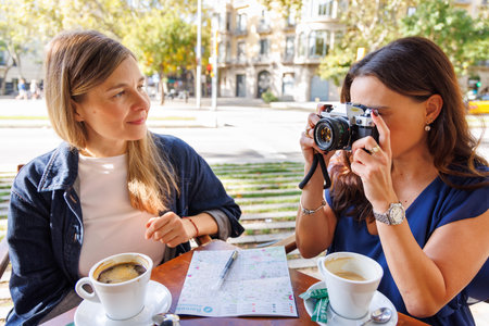 Smiling travelers share ideas and directions while enjoying a relaxing outdoor cafe