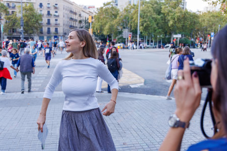Happy women enjoy sightseeing and capture memories posing playfully next to a historical monument.の写真素材