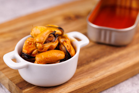 Canned mussels in orange sauce with simple and clean food presentation style.
