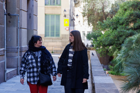 A mother and daughter walk together through old streets, talking and admiring boutique windows...