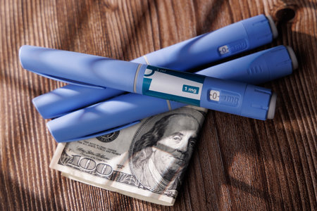 Professional image of semaglutide GLP-1 injectors on a dark wood surface with US money represents the expensive price of health and weight managementの写真素材