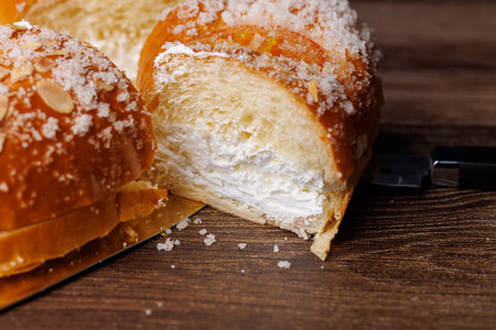 Delicious Spanish Kings cake with a generous cream layer and candied fruits on a dark wood surface. A perfect festive dessert for Three Kings Day!!の写真素材