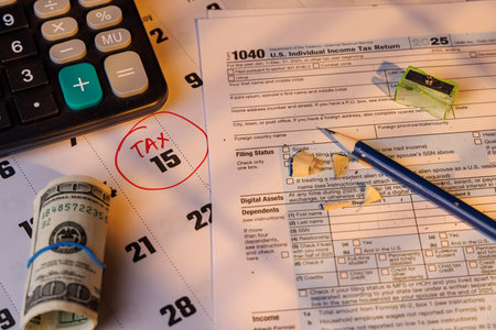 US income tax filing reminder with money and color Form 1040 on desk. Soft sun light represents...