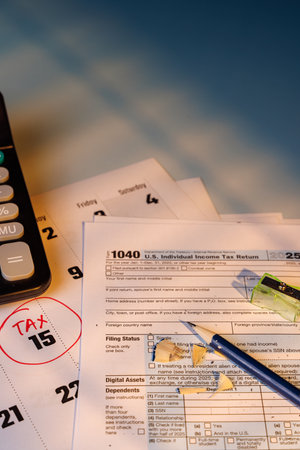 Financial tax deadline reminder with color Form 1040 and a marked calendar. Sunlight on the desk...