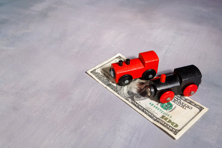 Toy train on money notes. Ideal for representing the high price of moving, transport poverty and the financial gap in global urban travel systems.の写真素材