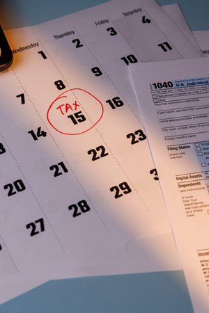 Professional shot of a calendar with a tax deadline and color Form 1040. Natural sunlight on the...