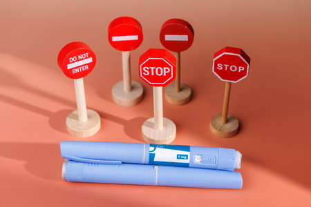 Close up of medication devices with warning symbols. Great for representing health hazards,...