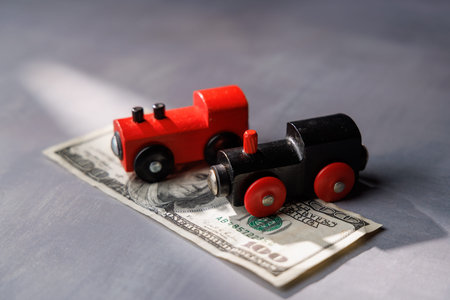 Toy train on money notes. Ideal for representing the high price of moving, transport poverty and the financial gap in global urban travel systems.の写真素材