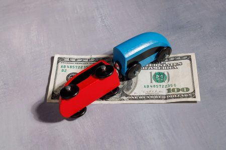 Toy train derailed on dollar money. Concept of loss of control, economic tragedy and the safety of the dollar currency in the modern business world.の写真素材