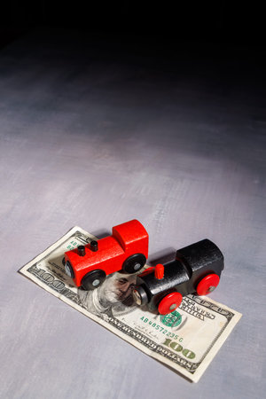 Wooden toy train on money bills. Ideal for representing expensive commuting, financial barriers to travel and the wealth gap in transportation.の写真素材