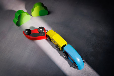 Wooden toy train with an accident on tracks. Ideal for representing planning failure, infrastructure risk and the impact of out of control events.の写真素材