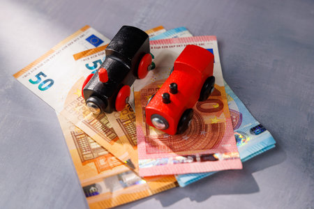 Conceptual shot of a toy train on banknotes. Ideal for representing the high cost of moving, travel debt and transport inaccessibility issues.の写真素材