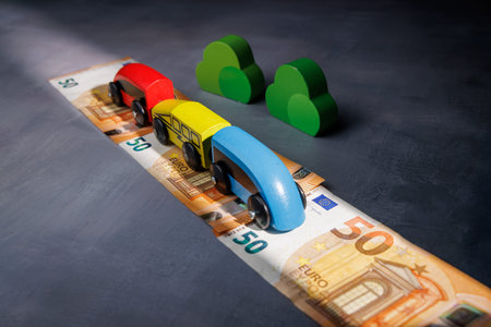 Wooden toy train on cash. Ideal for representing the high price of tickets, economic barriers to...