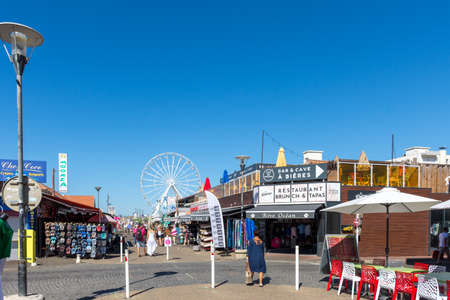 BISCARROSSE, FRANCE - 09-04-2020: dominated by a Ferris wheel installed for the summer, the 'Avenue de la Plage' is a pedestrian street that leads to the beach in the middle of shops and restaurantsのeditorial素材