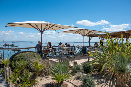 Cap Ferret, France - April 30 2024: An oyster tasting terrace by the water in the L'Herbe oyster districtのeditorial素材