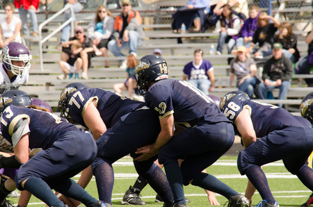 Nederland, CO: August 30, 2014- Elbert High School vs Nederland High School- American football player running to catch the football Center snaps the football to the quarterbackのeditorial素材