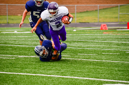 Football player being tackled by the ankles from the groundのeditorial素材