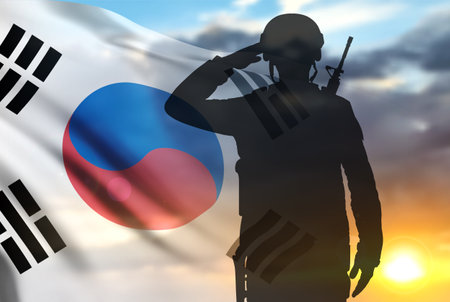 Silhouette of soldier saluting with South Korea flag on background of sunrise or sunset. Armed forces of Korea conceptの写真素材
