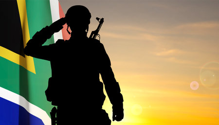 Silhouette of a saluting soldier with South Africa flag against the sunset. eps10 vectorのイラスト素材