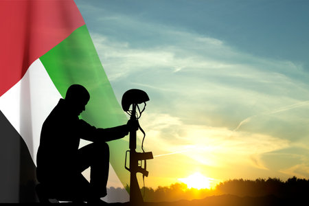 Silhouette of a solider kneeling down with UAE flag against the sunset. Concept - UAE national holidays, National Day, Commemoration Dayの写真素材