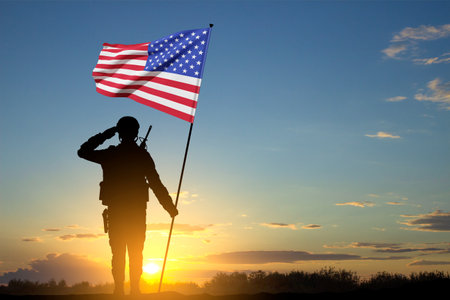 Silhouette of soldier with USA flag against the sunsetの写真素材