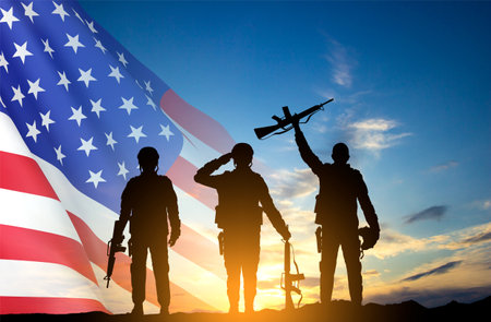Silhouettes of soldiers with USA flag against the sunsetの写真素材