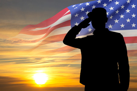 Silhouette of soldier with USA flag against the sunset. Greeting card for Veterans Day, Memorial Day, Independence Dayの写真素材
