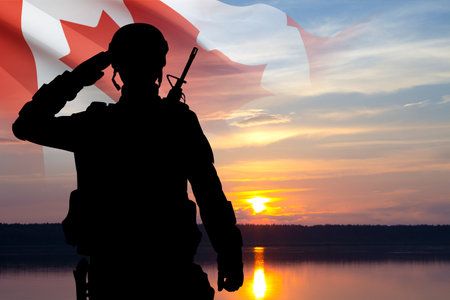 Silhouette of saluting soldier with Canada flag against sunset sky. Armed Forces of Canadaの写真素材