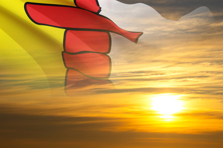 Flag of Nunavut against the sunset. Province of Canadaの写真素材