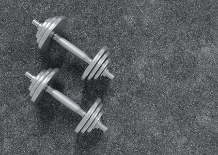 Dumbbells on grey textured background. Fitness or bodybuilding concept background. 3d-renderingの写真素材