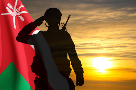 Silhouette of a soldier with the Oman flag against the sunsetの写真素材