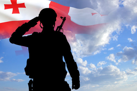 Silhouette of a soldier with the Georgia flag on background of sky