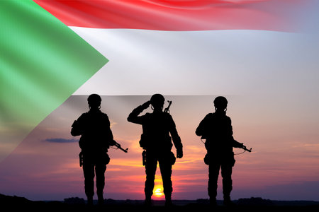 Silhouettes of soldiers with the Sudan flag against the sunset. National Holidays concept. Armed Force of Sudanの写真素材