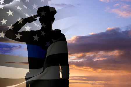 Silhouette of a police officer against the sunset. American flag with police support symbol. Thin blue line. National Law Enforcement Appreciation Day conceptの写真素材