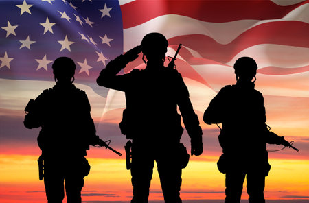 Silhouettes of a soldiers with USA flag against the sunset. Veterans Day, Memorial Day conceptの写真素材