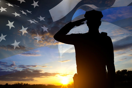 Silhouette of police officer and black USA flag with Thin Blue Line against the sunset. National Law Enforcement Appreciation Day conceptの写真素材