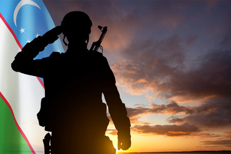 Silhouette of a soldier with Uzbekistan flag against the sunsetの写真素材