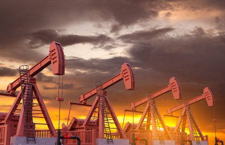 Oil well pumpjacks against the sunset.の写真素材
