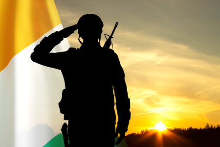 Silhouette of a soldier against the sunset with Ivory Coast flag. National Holidays conceptの写真素材