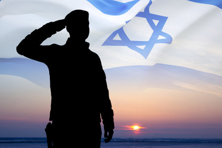 Silhouette of soldier against the sunset with Israel flag. National Holidays conceptの写真素材