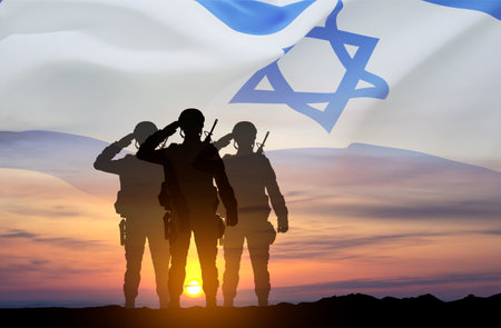 Silhouettes of soldiers against the sunset with Israel flag. National Holidays conceptの写真素材