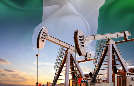Oil pumpjacks against the sunset with Nigeria flag. Oil industry conceptの写真素材