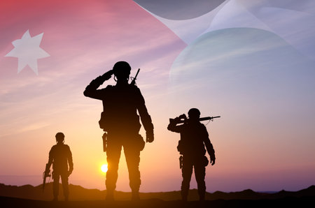 Silhouettes of a soldiers with Jordan flag against the sunsetの写真素材