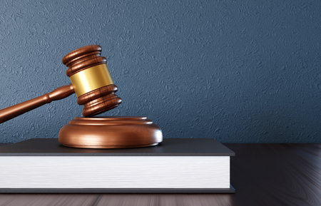 Wooden judge gavel with book on the desk near blue wallの写真素材